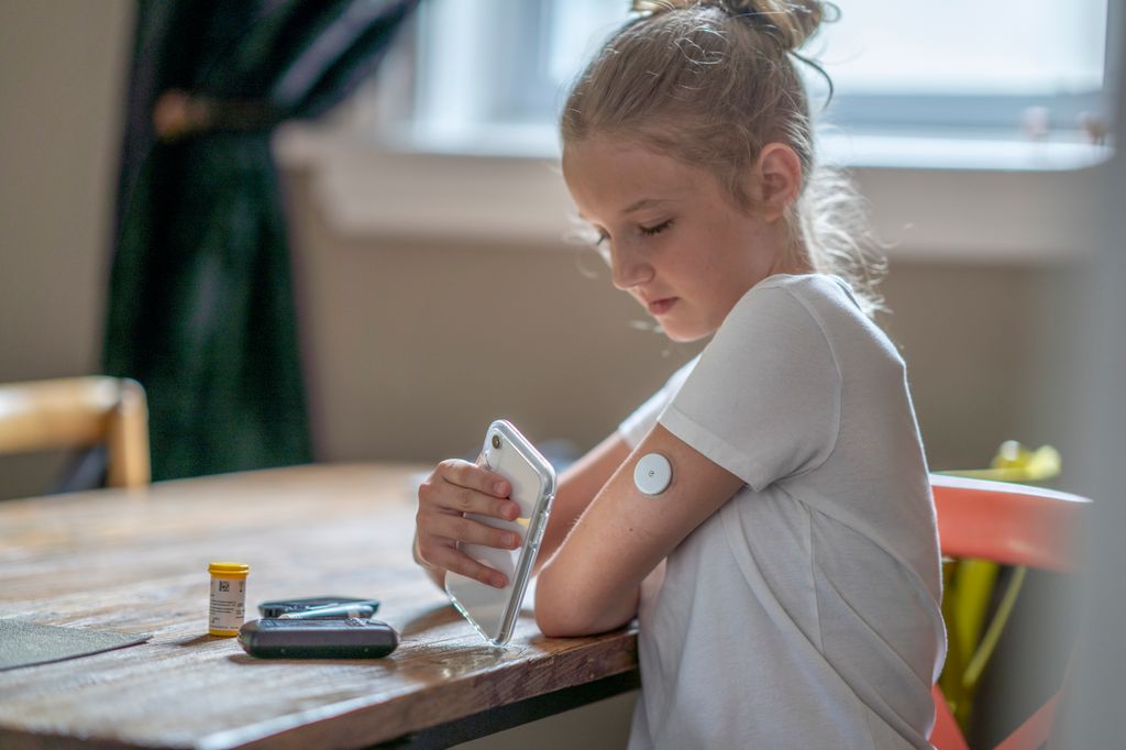 Niña midiendo sus niveles de diabetes en su sensor