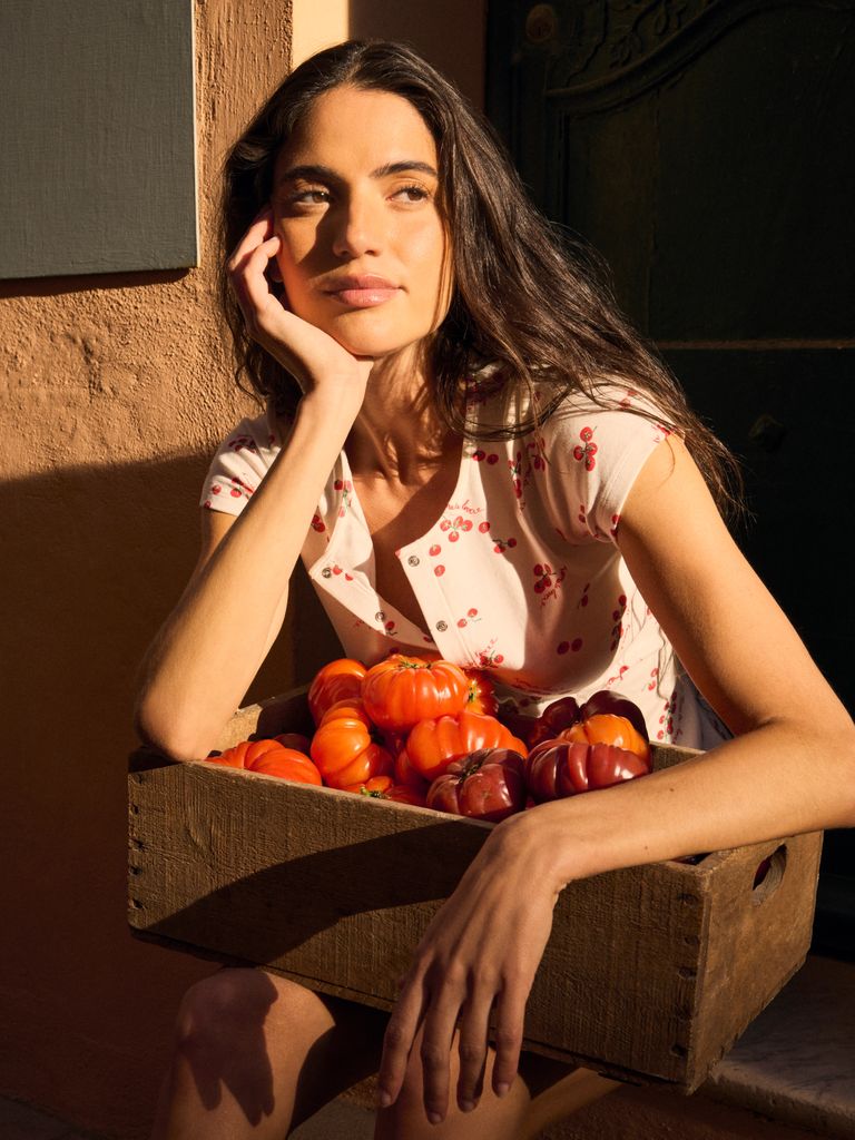 Mujer con una caja de tomates