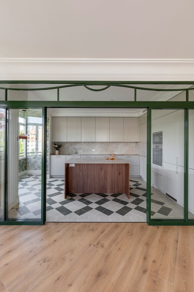 Cocina y comedor se mantienen conectados visualmente, pero se crea una transición entre ambos mediante una cristalera y el uso de dos pavimentos distintos