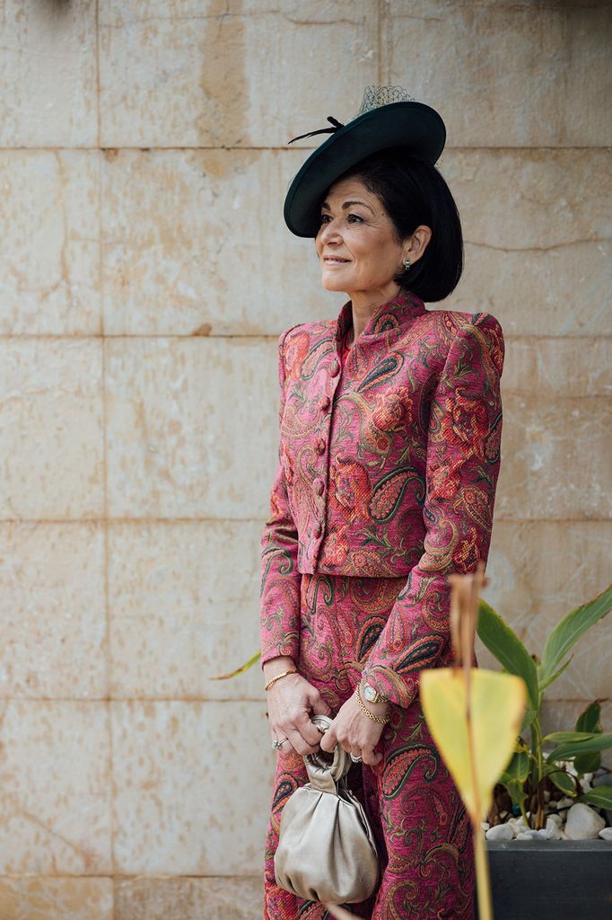 Madre de la novia con traje estampado de jacquard de colores y tocado