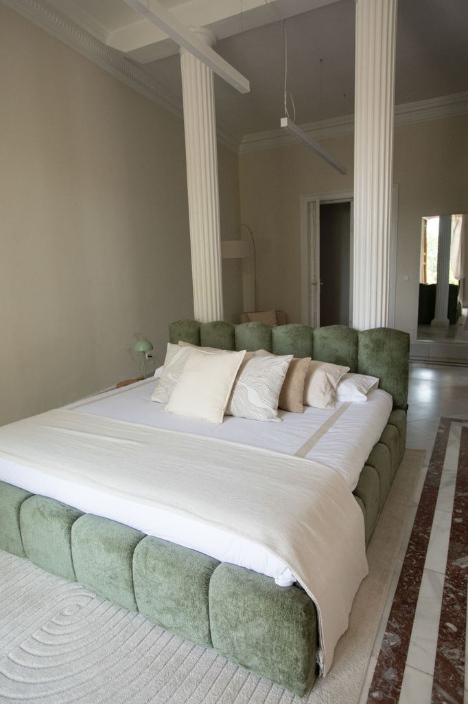 Dormitorio con cama entre columnas