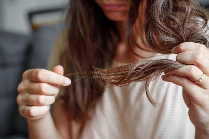 mujer que ve cómo se cae su pelo