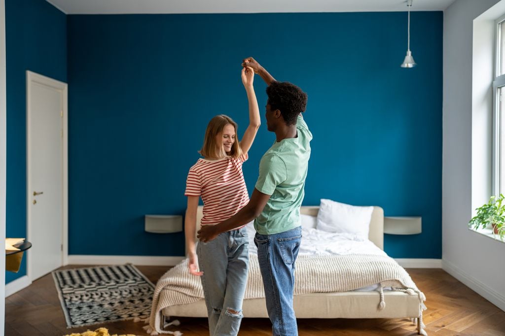 pareja feliz bailando en la habitación de su casa
