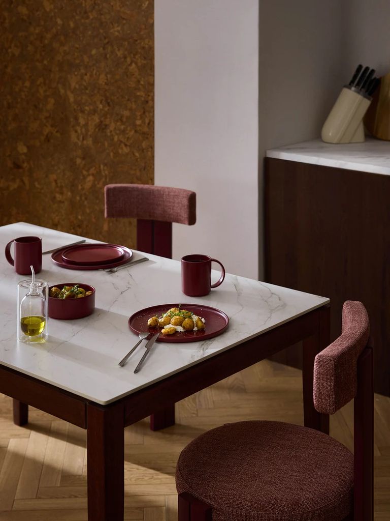 Comedor decorado con elementos granates de la colección de otoño 2026 de Westwing.