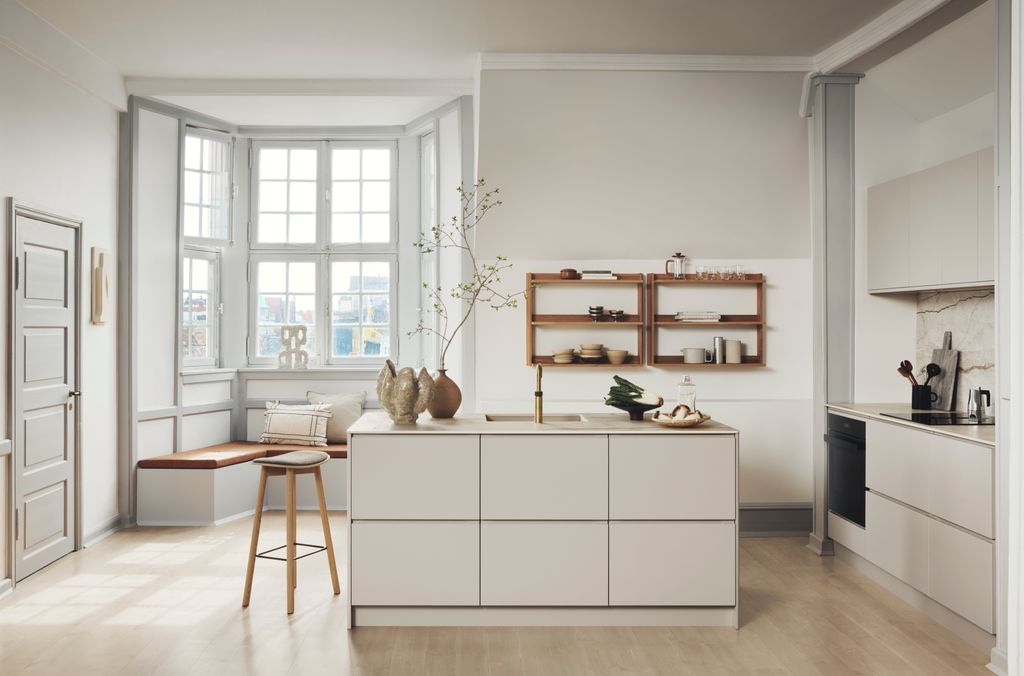 Cocina pensada para permanecer, con isla y un banco bajo el ventanal