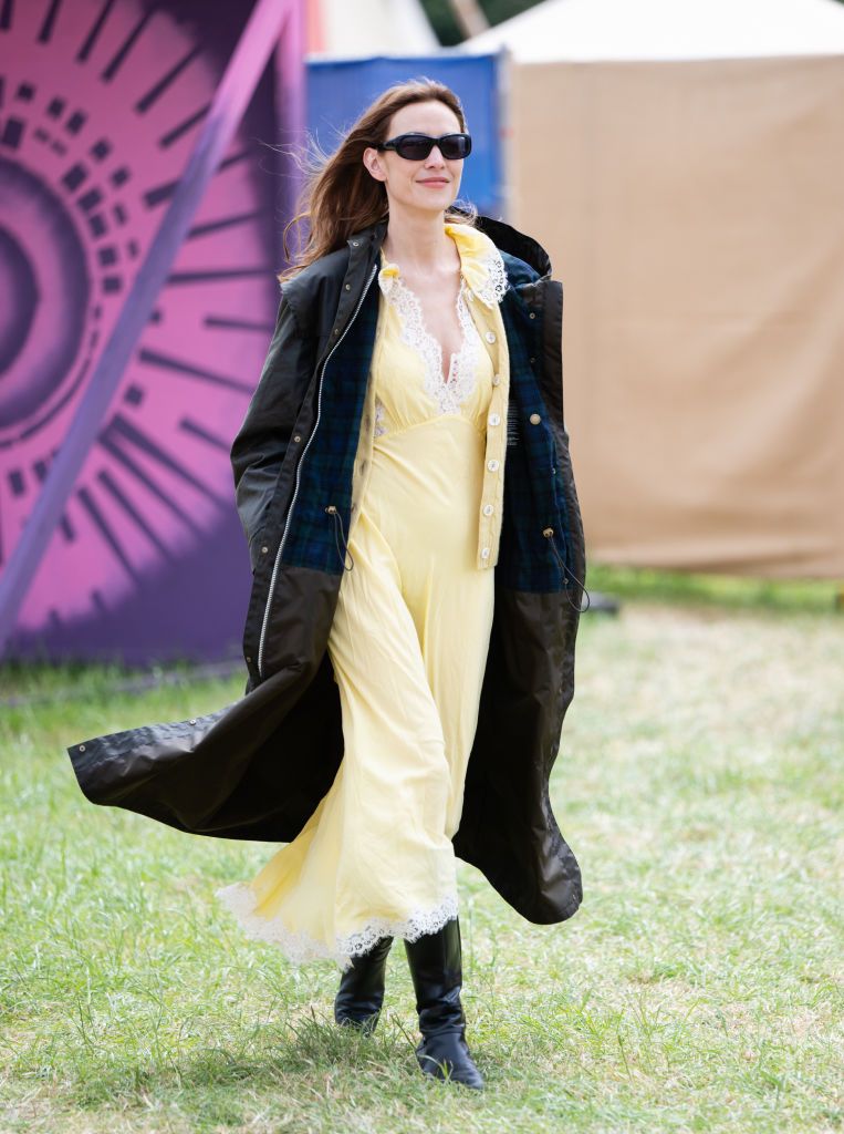 Alexa Chung demuestra que la manera de vestir para Glastonbury es combinando un vestido súper femenino con un abrigo tipo rompevientos, el balance perfecto. 