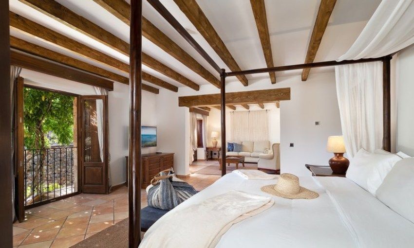 Las 25 habitaciones cuentan con grandes camas con dosel, mobiliario rústico y jardín o terraza.