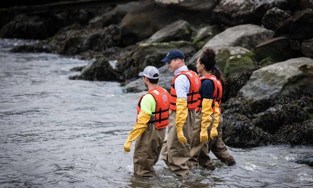 the prince donned waders and yellow gloves to wade in the water 