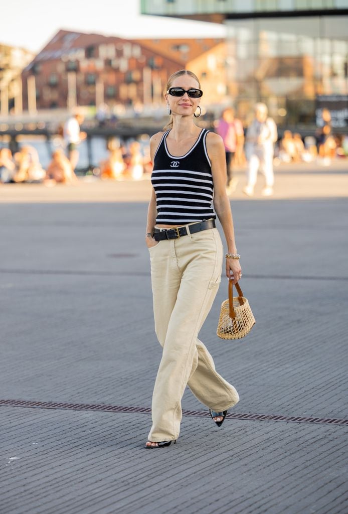 COPENHAGUE, DINAMARCA - 11 DE AGOSTO: Pernille Teisbaek vista con top Chanel a rayas blanco y negro, pendientes, pantalones beige, bolso de red fuera de Ganni durante la Semana de la Moda de Copenhague Primavera/Verano 2023 el 11 de agosto de 2022 en Copenhague, Dinamarca. (Foto de Christian Vierig/Getty Images)