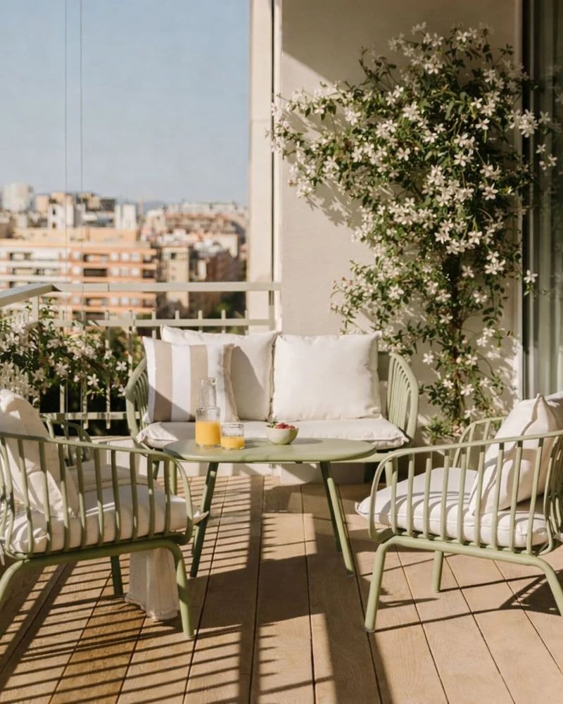 Comedor de verano en una terraza urbana decorada con un jazmín común (‘Jasminum officinale’), una de las plantas que en España identificamos con el verano