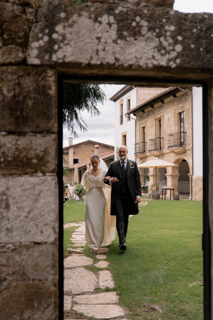 Padre de la novia a la izquierda de ella en entrada a la boda