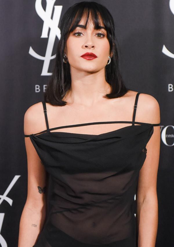 Aitana posando en un photocall con vestido negro