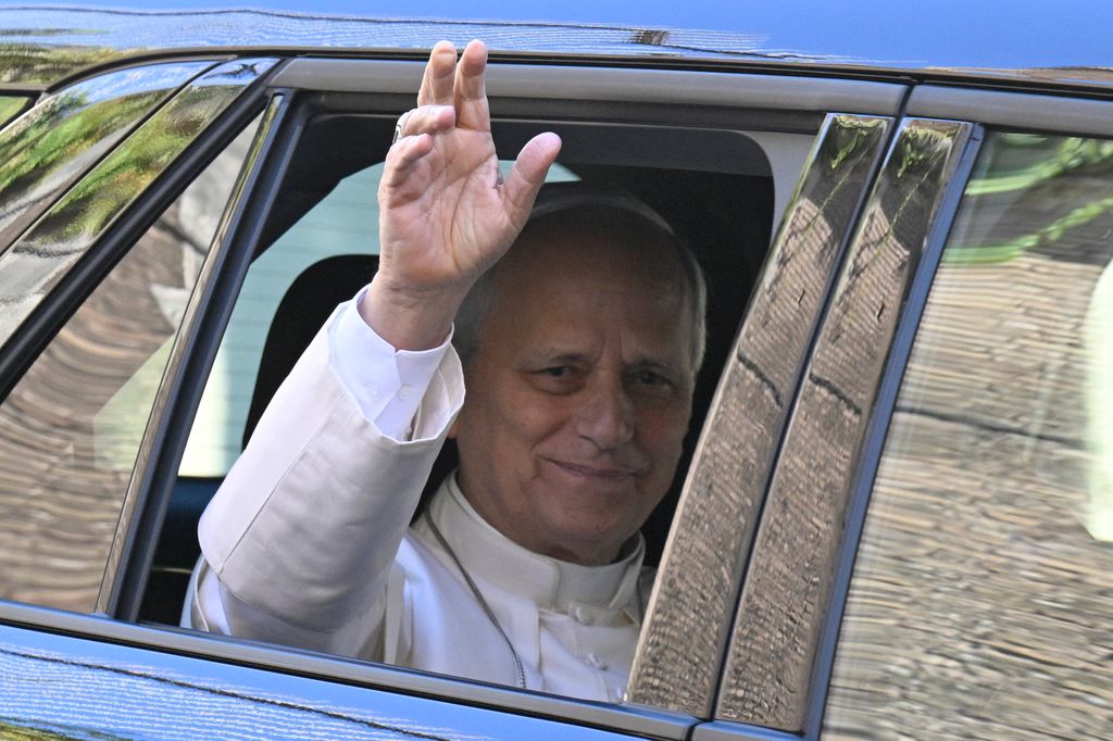 Pope Leo XIV waves from the window of the car as he leaves the Vatican before being admitted to Rome's Gemelli University Hospital for an operation to remove a lump from his lung, in the Vatican on 13 October 2026.  (Photo by Tiziana FABI / AFP via Getty Images)