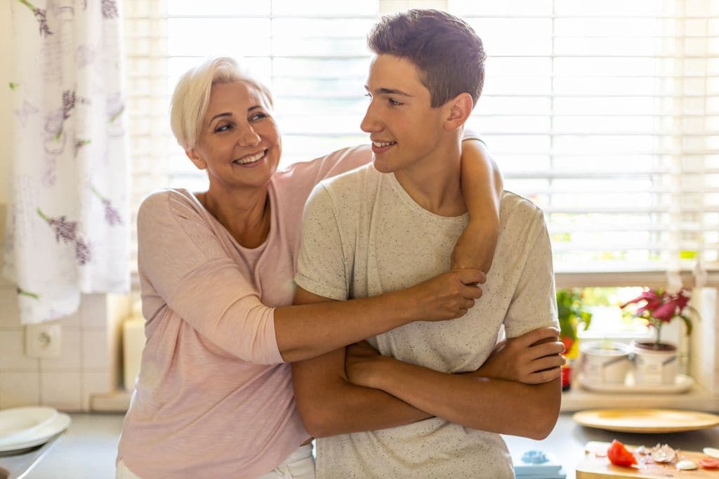 Madre abrazando a su hijo adolescente