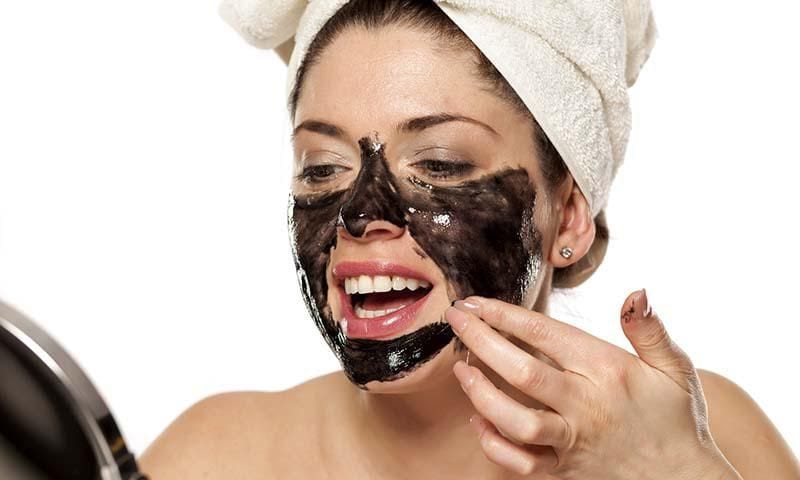 mujer aplica carbon vegetal