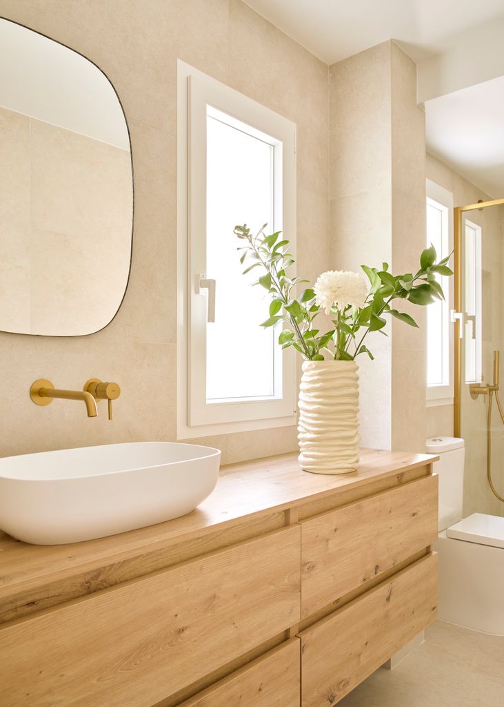 Baño con mueble de madera y grifería de bronce