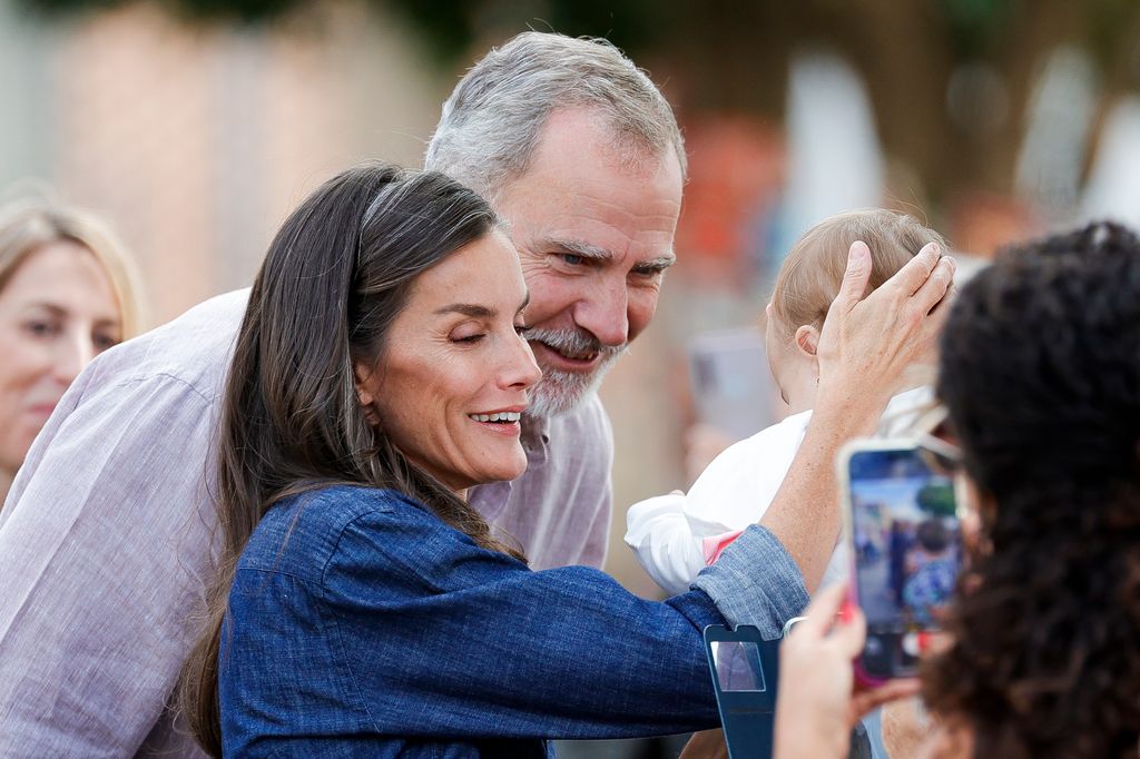 Los reyes Felipe y Letizia se paran con un bebé durante su visita a Extremadura