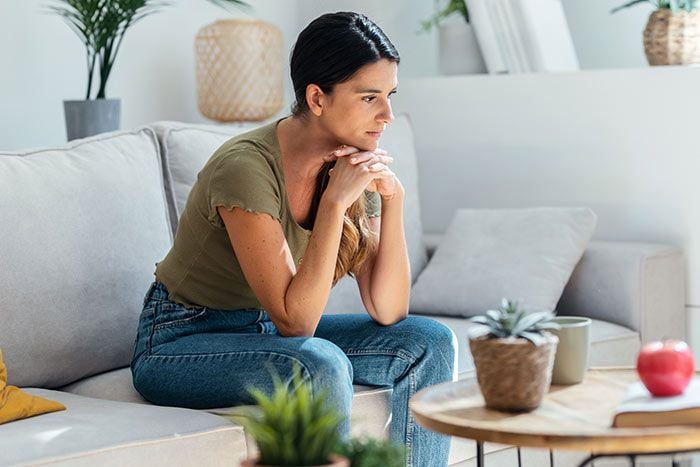 mujer seria en el sofá