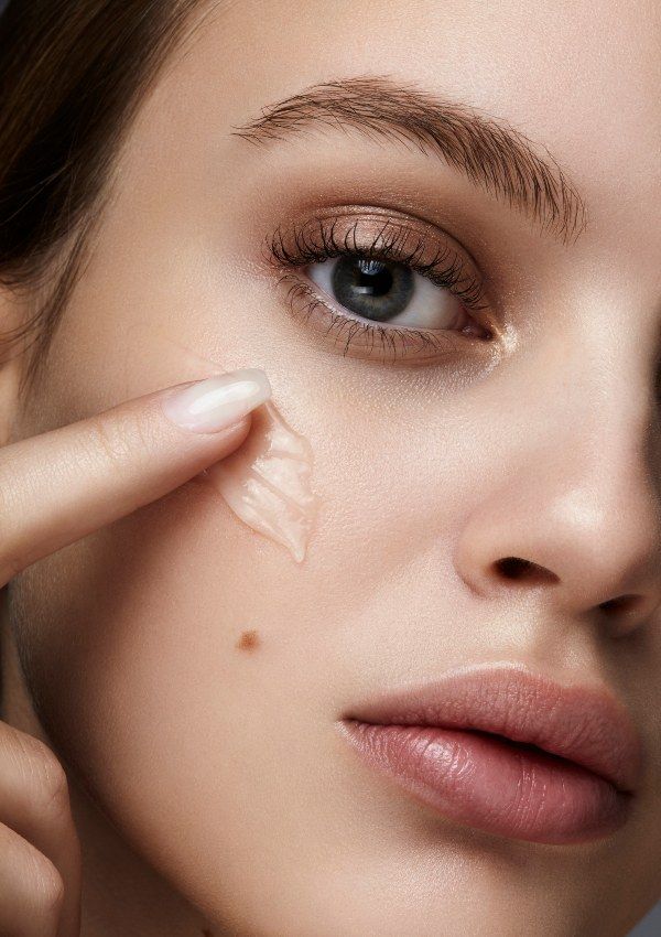 Persona aplicándose producto en el rostro