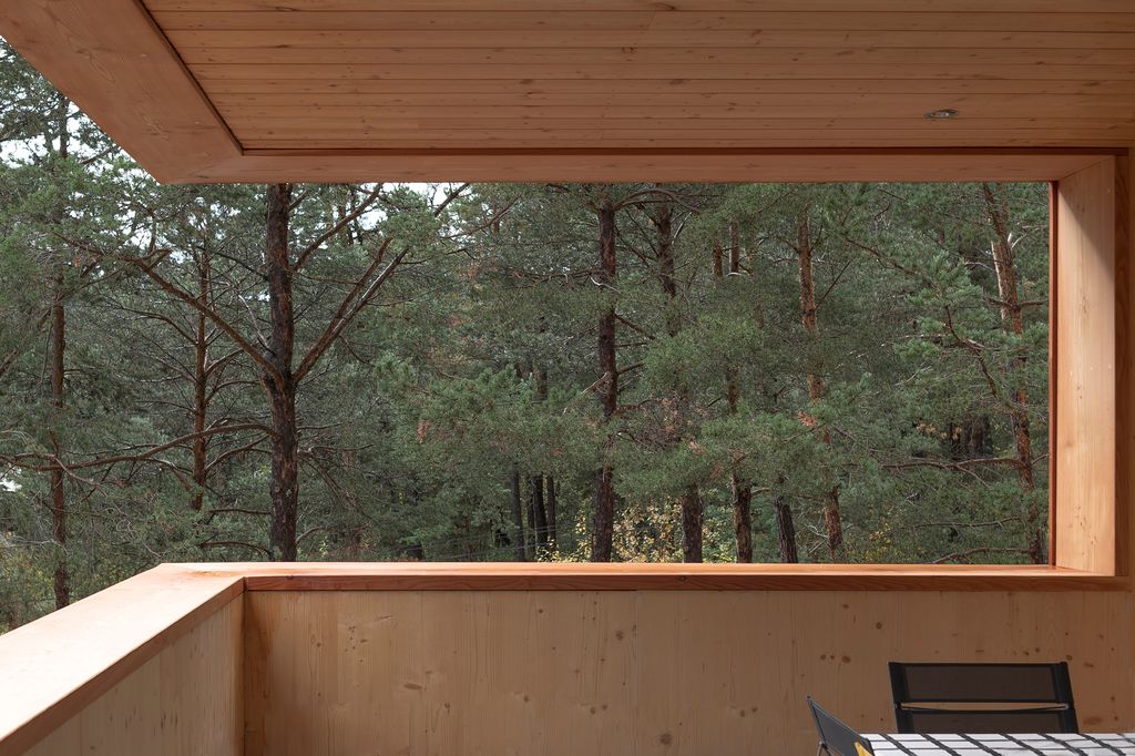 Terraza con vistas a los pinos circundantes, en la ‘Maison Les Marquises’, un refugio escondido en los Alpes ideado por Atelier d’Architecture Amasa