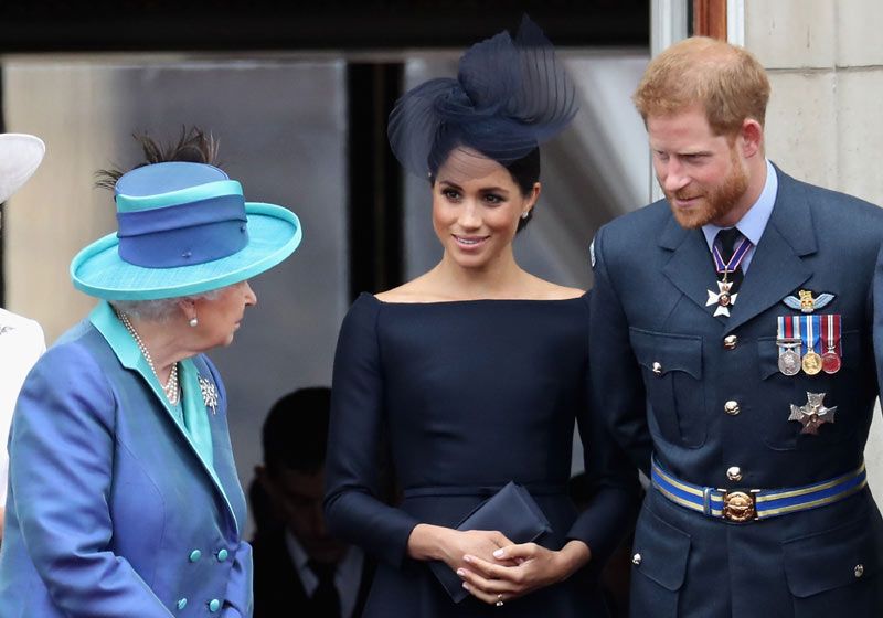Reina Isabel II de Inglaterra con Meghan Markle y el príncipe Harry