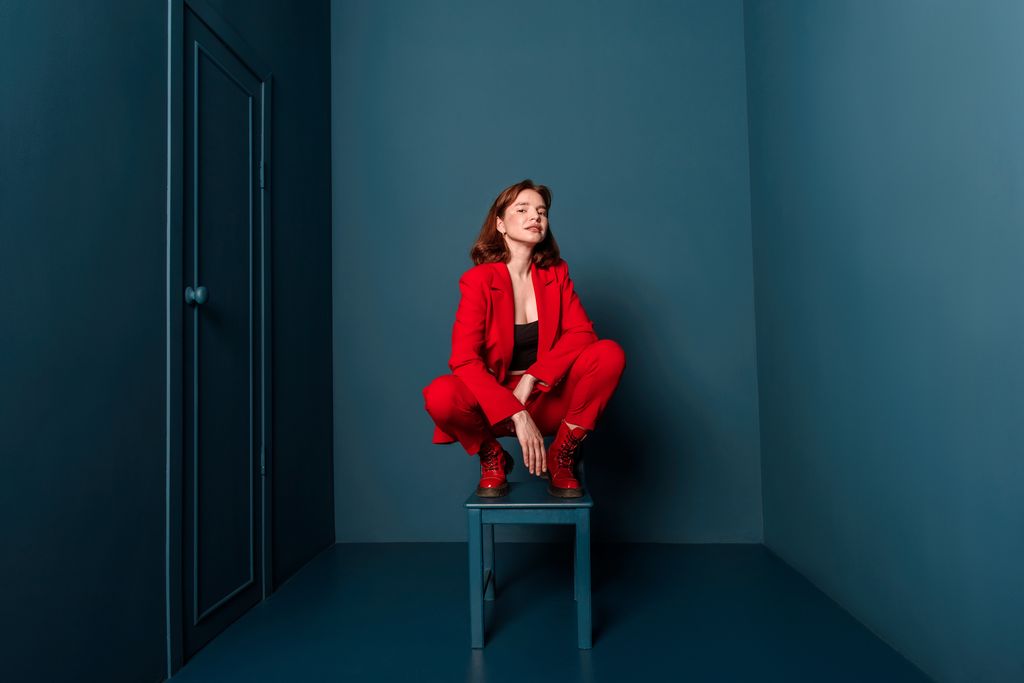 Mujer sentada en cuclillas sobre una silla