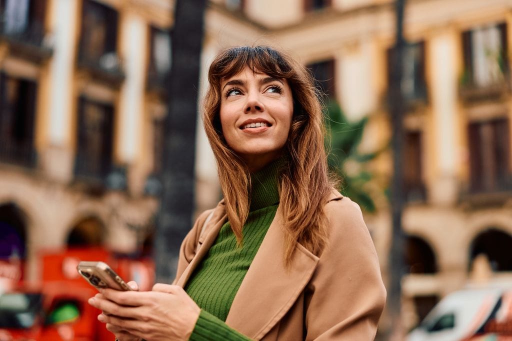 Mujer en la ciudad con el móvil en la mano