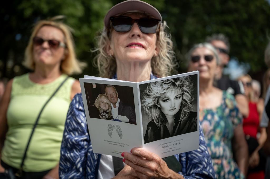 Una admiradora sostiene el programa del funeral de Bonnie Tyler, en el que aparece un retrato de la cantante y, en la contraportada, una imagen junto a su marido, Robert Sullivan