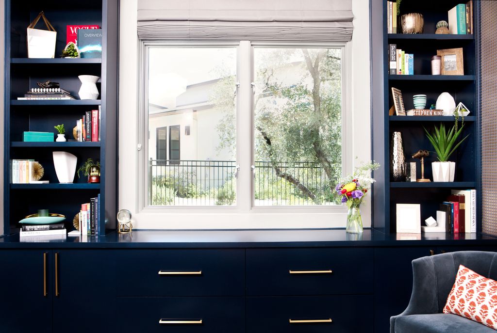 Estantería azul con libros y adornos en blanco
