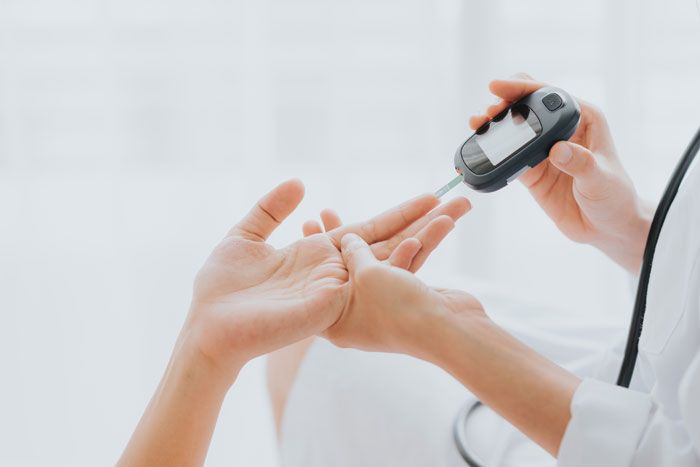 mujer midiendo sus niveles de glucosa
