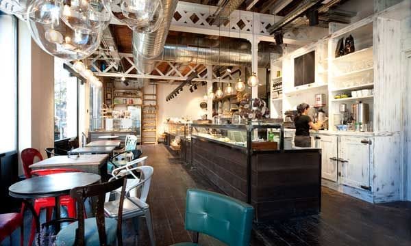 Las vigas y los sistemas de agua y electricidad a la vista imprimen a la panadería-cafetería Serrajòrdia un look industrial, muy en la línea de los locales neoyorquinos. Proyecto de AM Asociados (amasociados.es).
