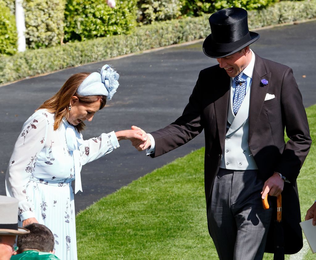 El príncipe de Gales ayuda a su suegra, Carole Middleton, a sacar el tacón de su zapato, que se quedó atrapado en el césped durante el segundo día del Royal Ascot, Inglaterra