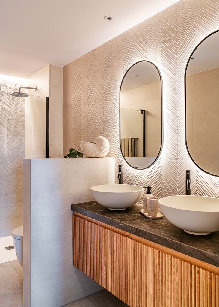 Baño con mueble volado de madera y encimera negra