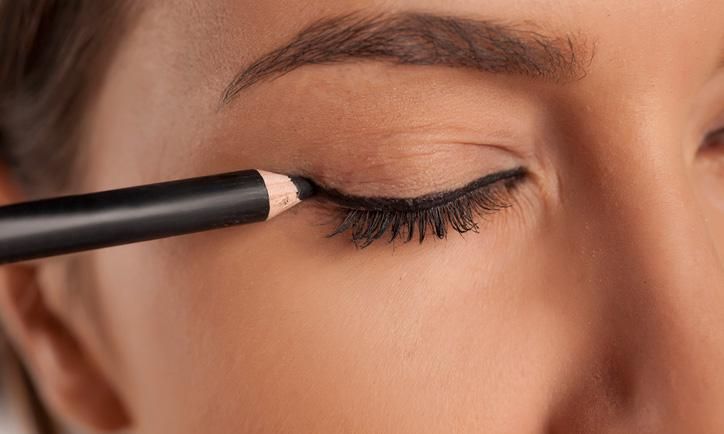 mujer aplica delineador de ojos