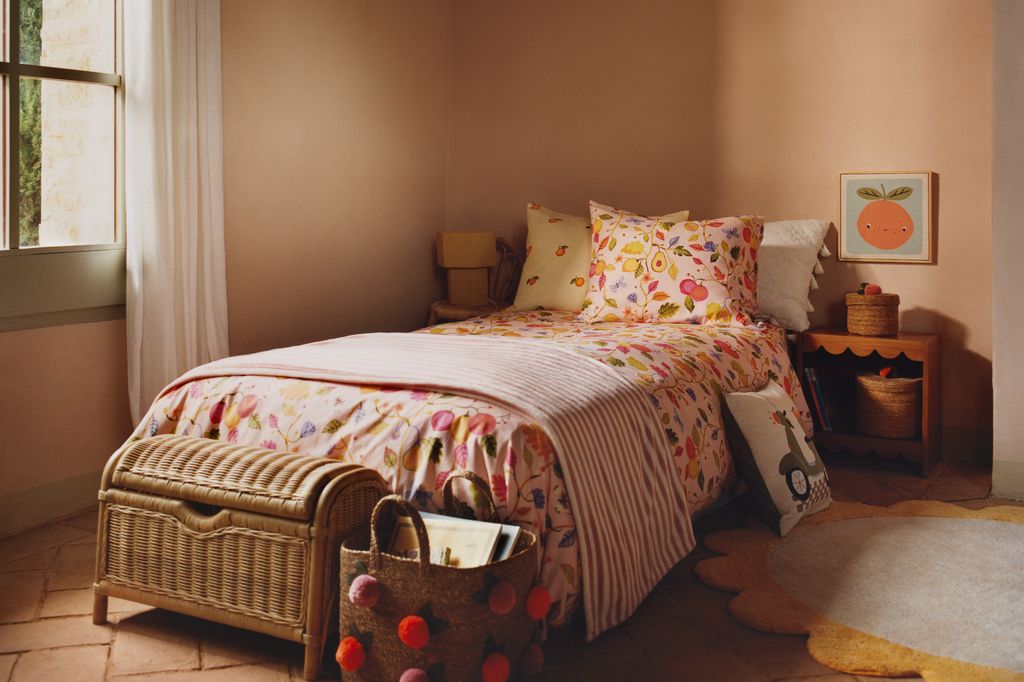 Habitación infantil con paredes en tono melocotón y textiles estampados