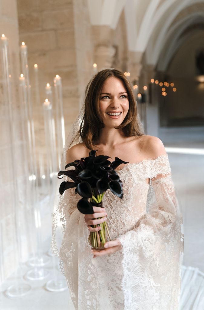 Stella Banderas el día de su boda, sosteniendo un ramo de novias formado por calas negras