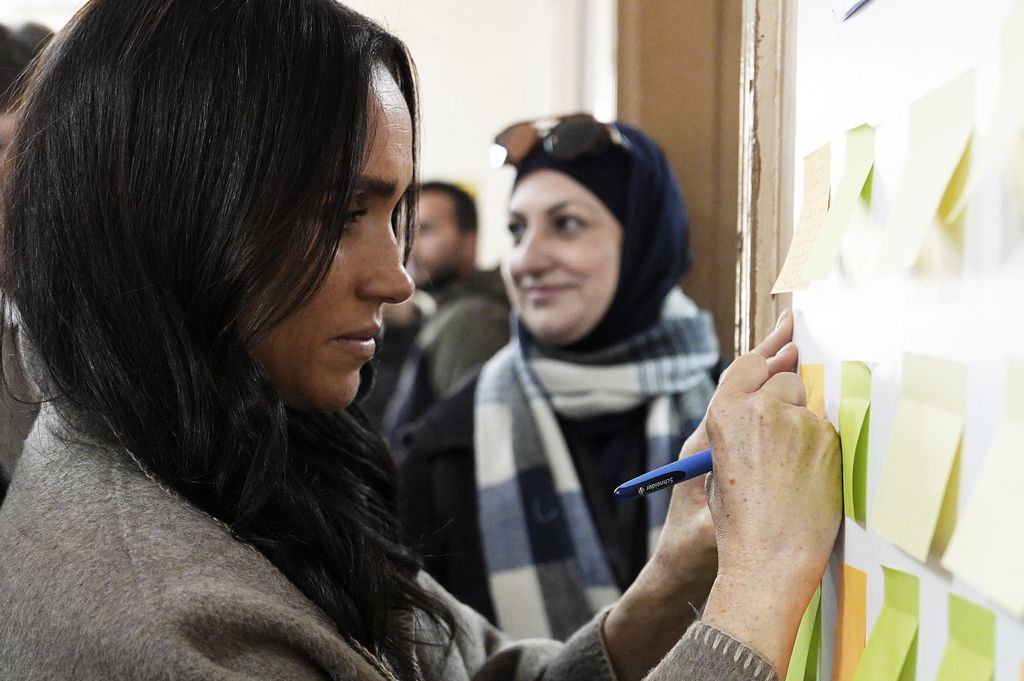 Meghan Markle escribiendo su mensaje en Jordania 