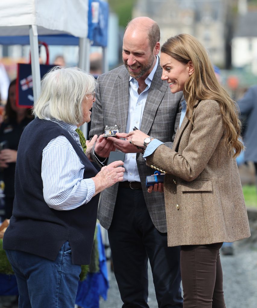 Prince William, Prince of Wales, known as the Duke of Rothesay and Catherine, Princess of Wales, known as the Duchess of Rothesay when in Scotland, smile at each other during a tour of an artisan market on April 29, 2025 in Tobermory, Scotland. The Prince and Princess of Wales are on a two-day visit to the Isles of Mull and Iona on the 29th and 30th of April to engage with rural island communities. During their time on the islands, they will connect with local residents, highlighting the value of social bonds and underscoring the importance of safeguarding and advocating for the natural environment.