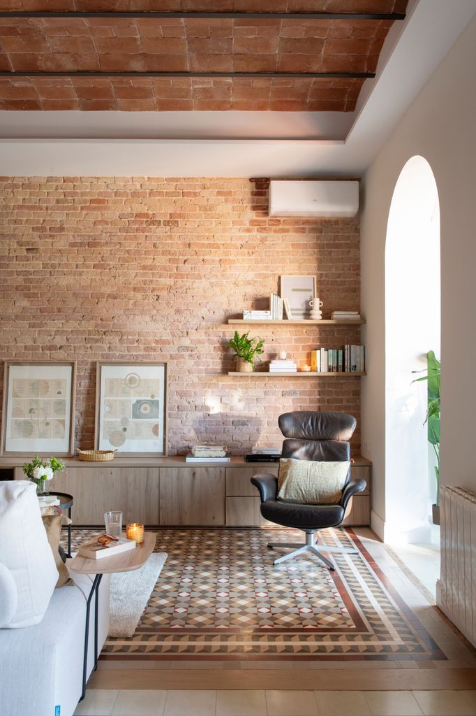 Salón con pared de ladrillo visto y suelo hidráulico