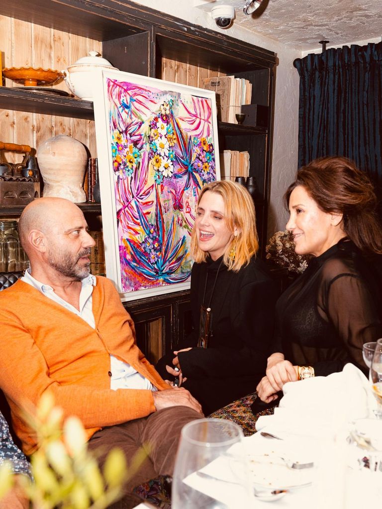 Macarena Gómez con unos amigos y una pintura de Aldo de fondo