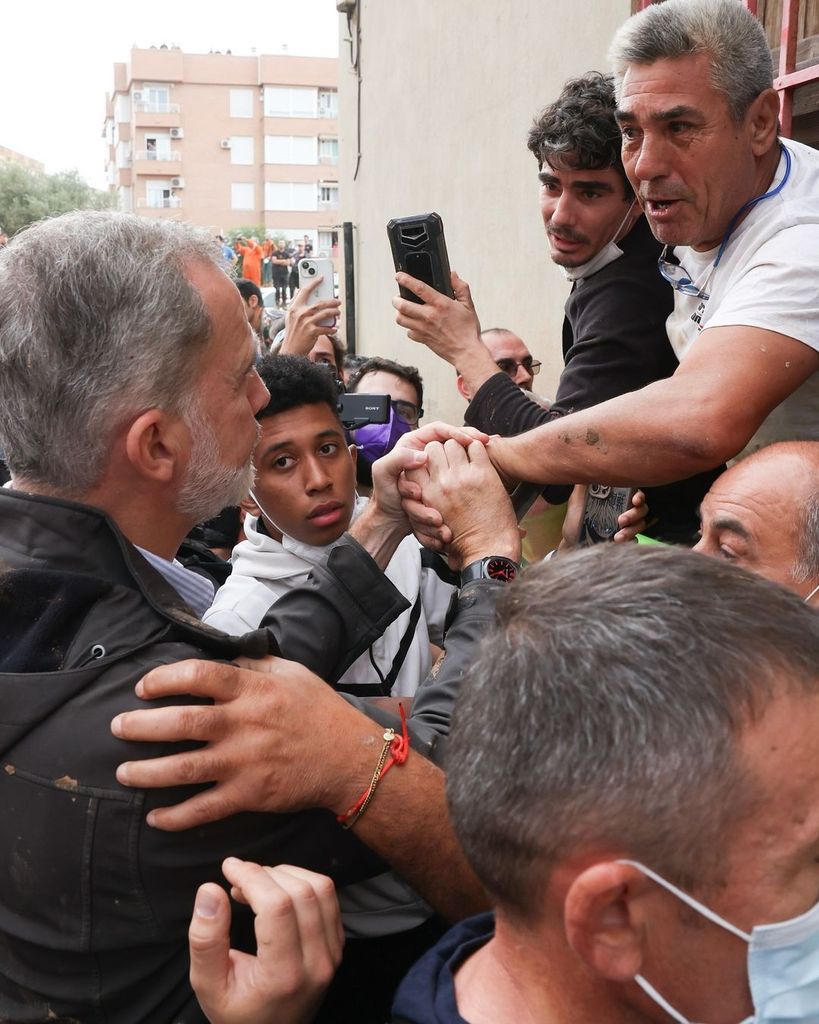 Plano medio del Rey Felipe hablando y dando ánimos a vecinos afectados por la DANA