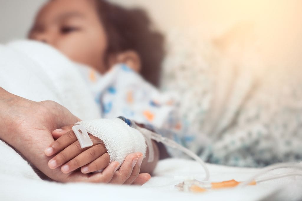 Niño en el hospital con meningitis de la mano de su madre