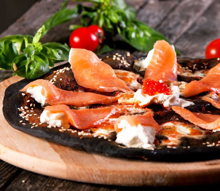 Pizza negra con salmón ahumado y queso crema