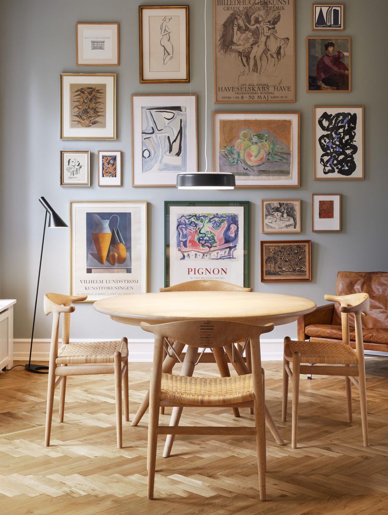 Pared del comedor decorada con composición de láminas