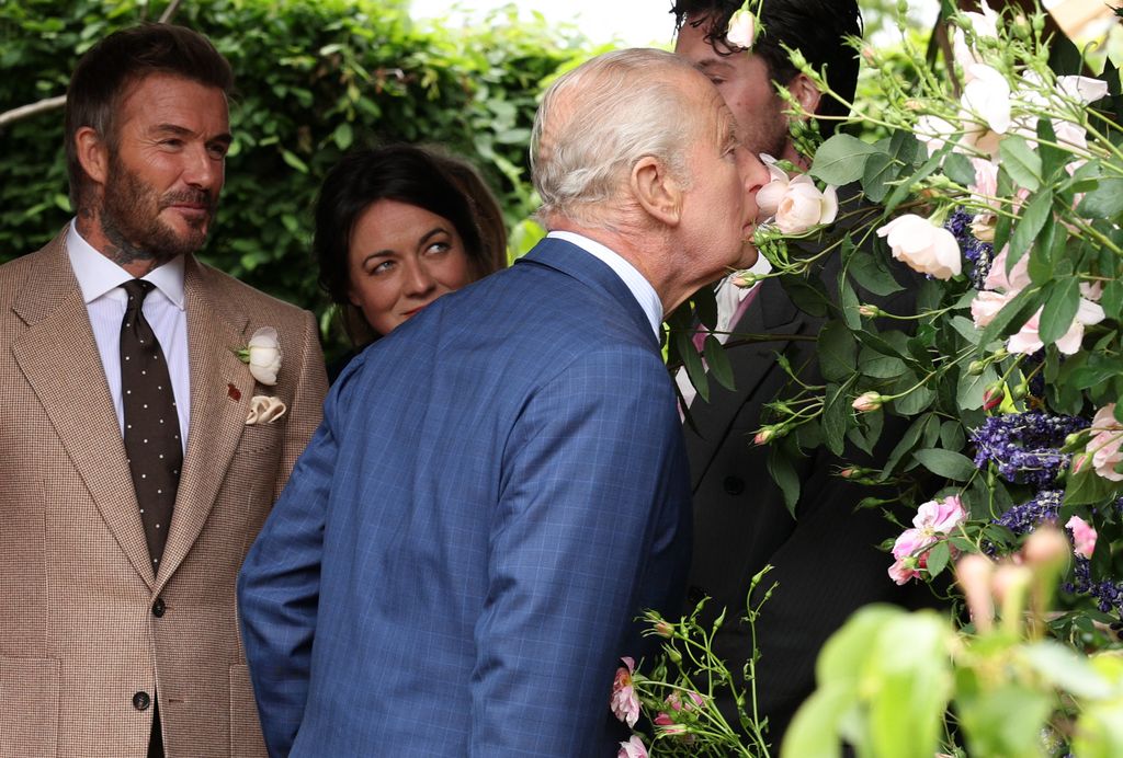 El rey Carlos III oliendo la flor que llevva el nombre de David Beckham 