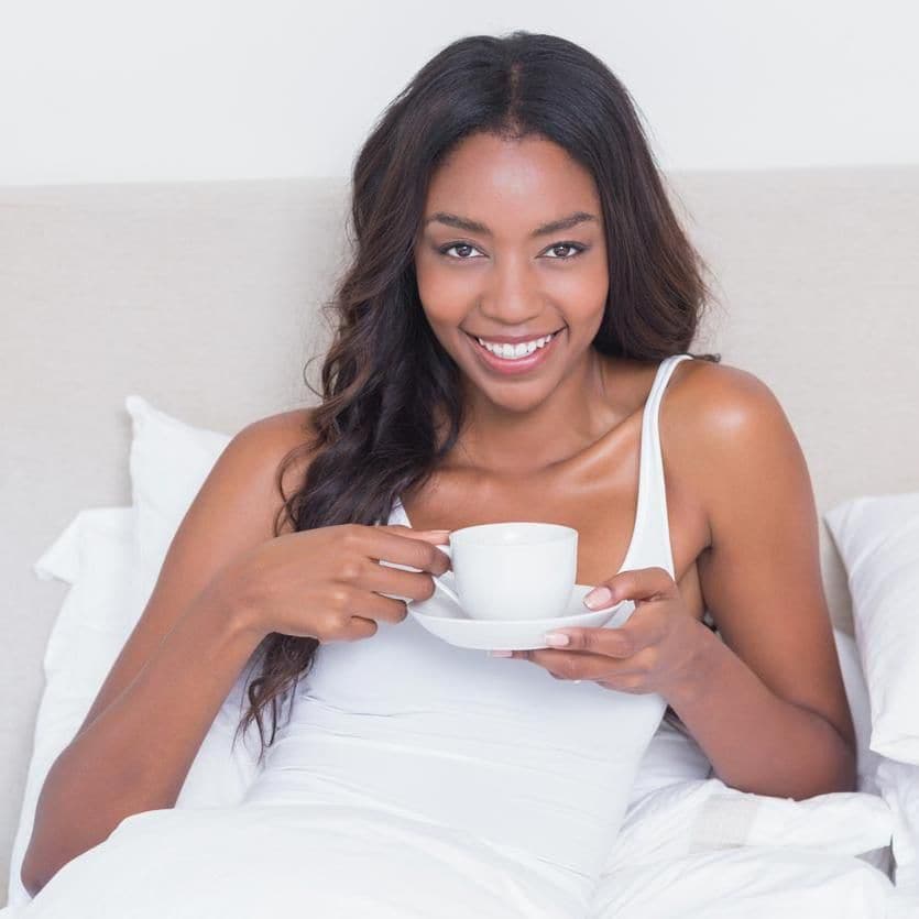 Chica toma té en su cama