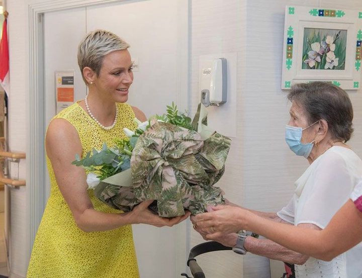 Charlene de Mónaco cambia de look con un vestido amarillo y collar de perlas