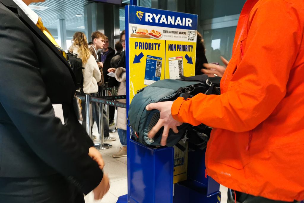 Los pasajeros están midiendo su equipaje en el medidor de Ryanair