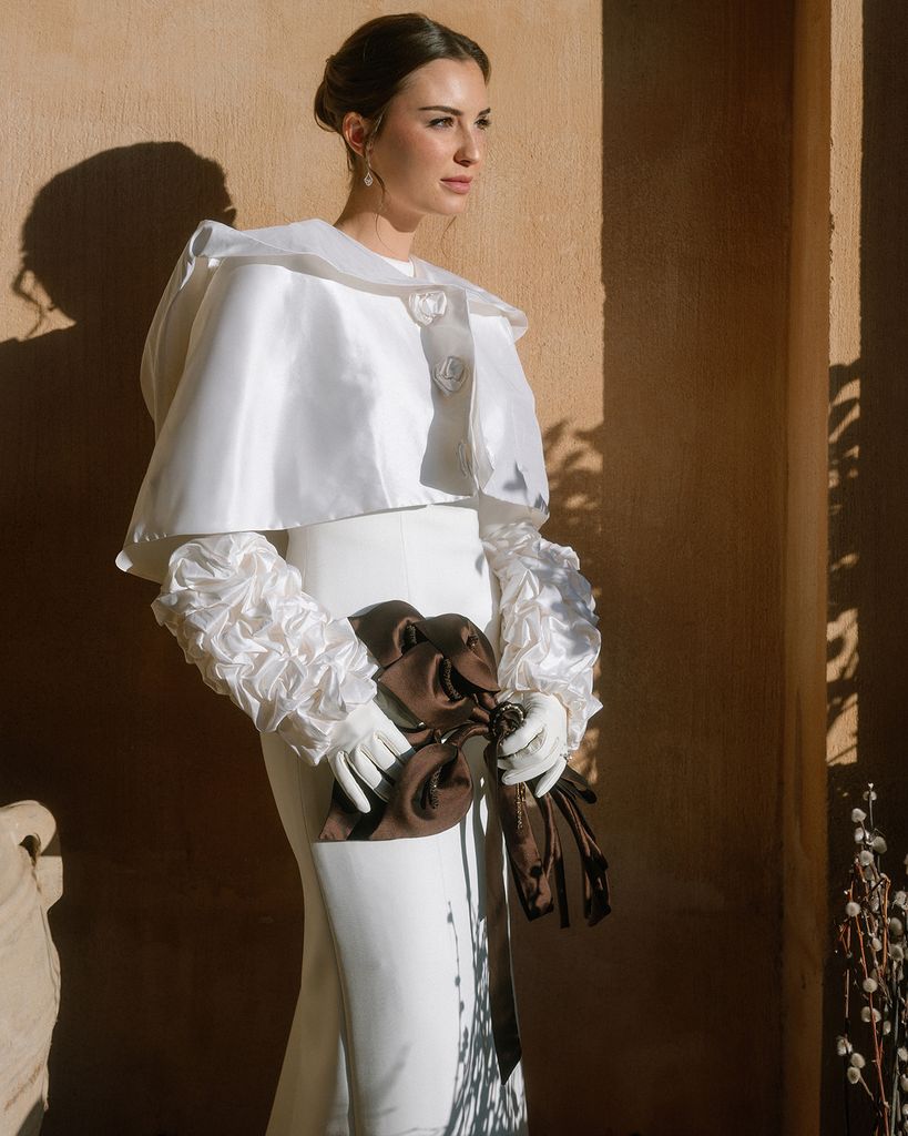 Vestido de novia de Lorenzo Caprile con capa y guantes de flores