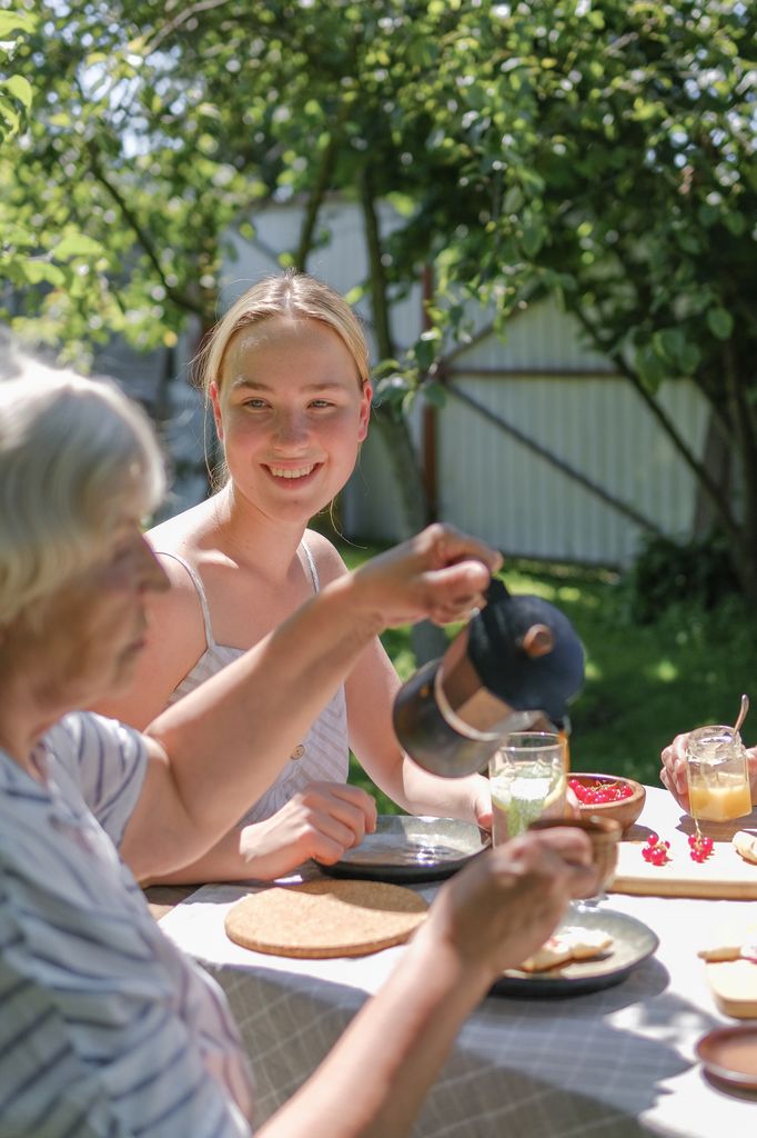 Chica comiendo con una mujer mayor